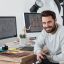 happy-photographer-holding-camera-at-his-desk-9REYFMZ.jpg